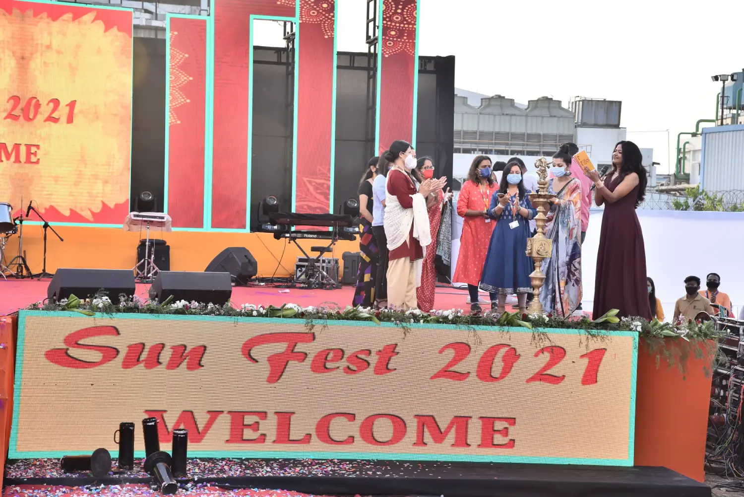 Man and woman speaking on stage at night with blue lighting